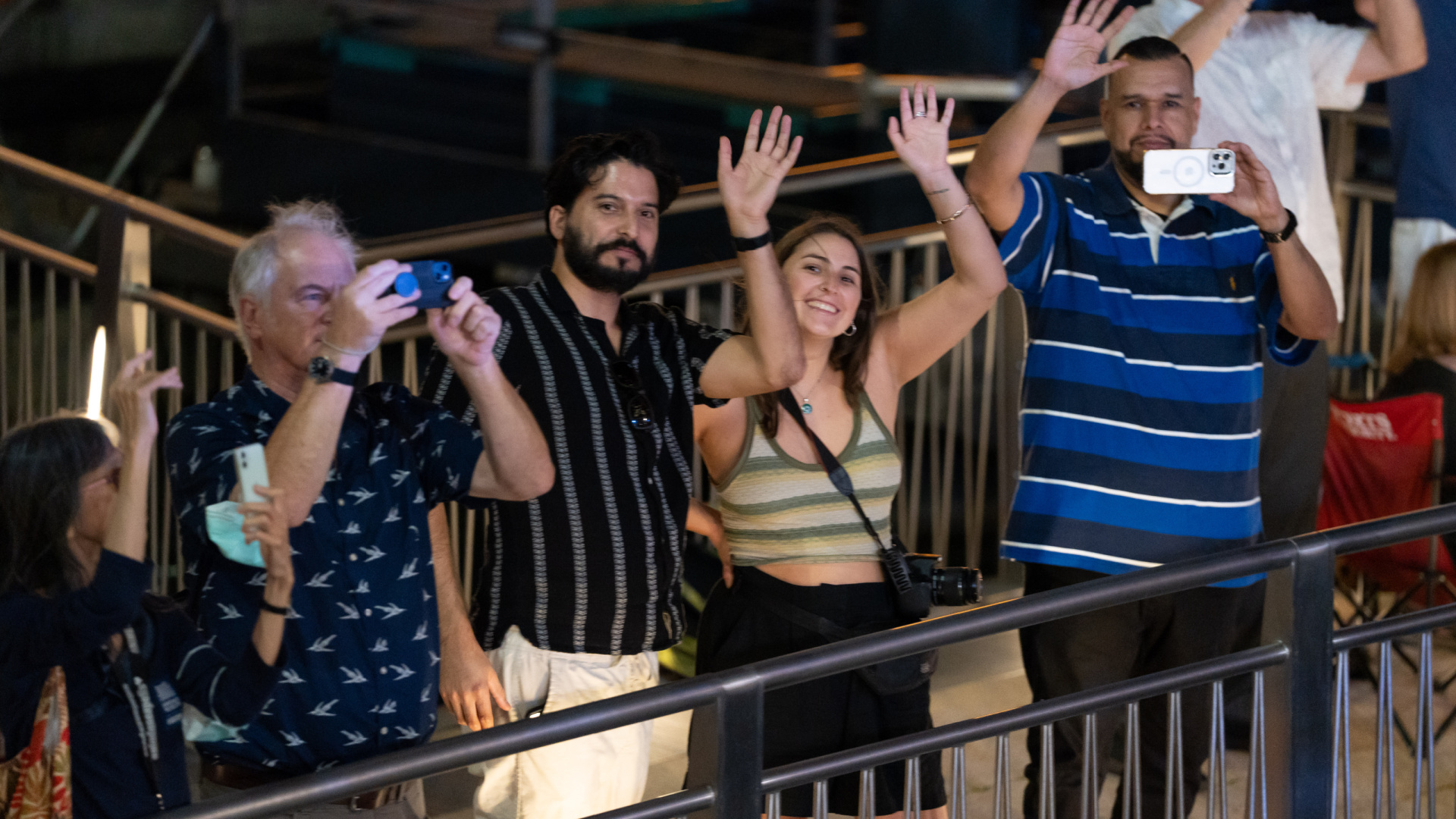 People waving along the Riverwalk