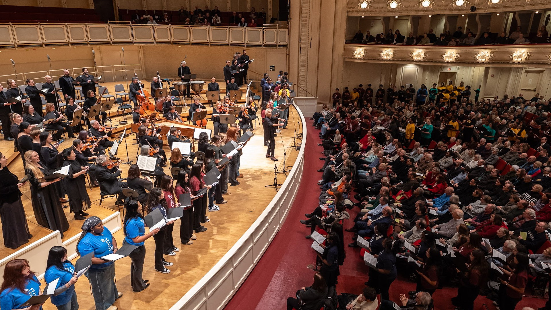 the Strong Voices Chorus on the stage at Symphony Center with the MOB Chorus and Orchestra